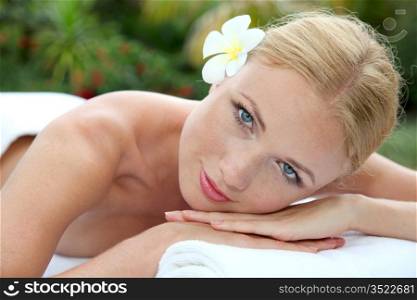 Portrait of beautiful blond woman relaxing on massage bed
