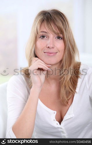 Portrait of beautiful blond woman sitting in sofa