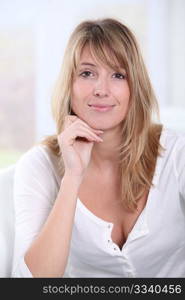 Portrait of beautiful blond woman sitting in sofa