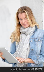 Portrait of beautiful blond woman using electronic tablet