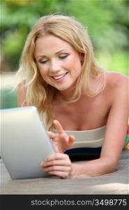 Portrait of beautiful blond woman using electronic tablet