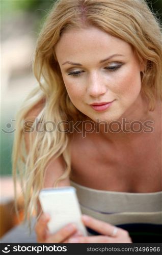 Portrait of beautiful blond woman using mobile phone