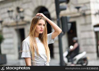 Portrait of beautiful blonde girl in urban background
