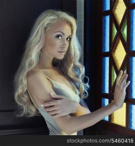 Portrait of beautiful blonde princess in stained window