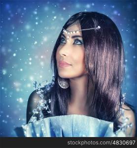 Portrait of beautiful brunet woman wearing stylish jewelery over dark snowy background, gorgeous snow queen looking up, fashionable look for Christmas party