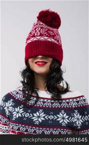 Portrait of beautiful brunette girl with knitted beanie on her face. Christmas mood