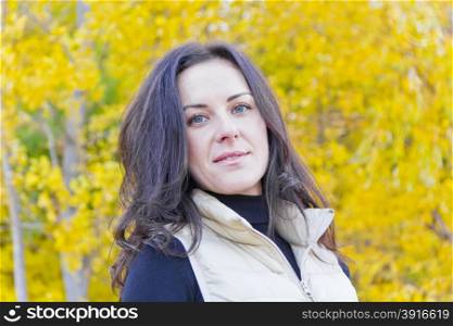 Portrait of beautiful brunette on yellow forest