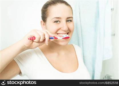 Portrait of beautiful brunette woman brushing teeth