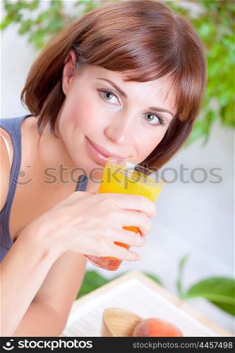 Portrait of beautiful brunette woman drinking tasty fresh juice on at home, having breakfast, organic nutrition, healthy lifestyle concept