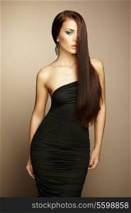 Portrait of beautiful brunette woman in black dress. Fashion photo
