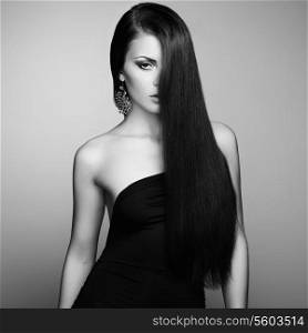 Portrait of beautiful brunette woman in black dress. Fashion photo
