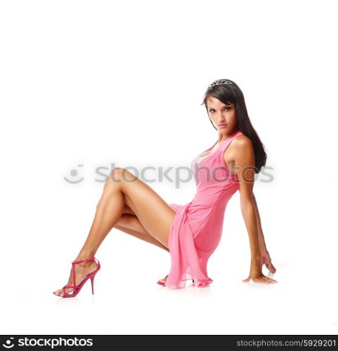 Portrait of beautiful brunette woman in sexy pink dress. Fashion photo. Sexy brunette sitting side view