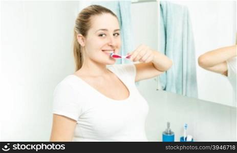 Portrait of beautiful brunette woman posing with tooth brush at bathroom