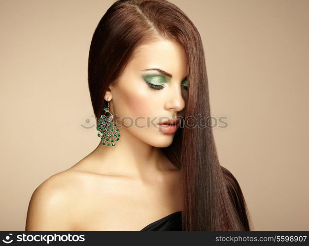 Portrait of beautiful brunette woman with earring. Perfect makeup. Fashion photo