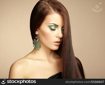 Portrait of beautiful brunette woman with earring. Perfect makeup. Fashion photo