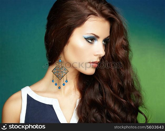 Portrait of beautiful brunette woman with earring. Perfect makeup. Fashion photo