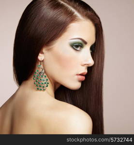 Portrait of beautiful brunette woman with earring. Perfect makeup. Fashion photo