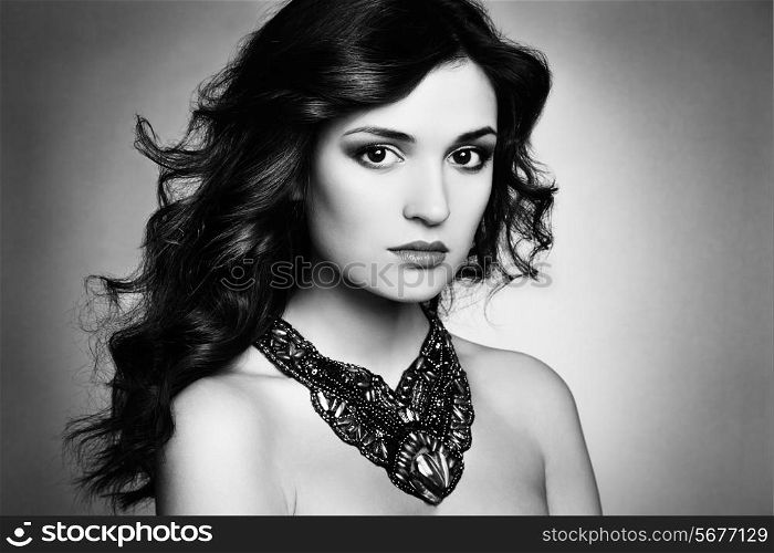 Portrait of beautiful brunette woman with earring. Perfect makeup. Fashion photo. Black and white