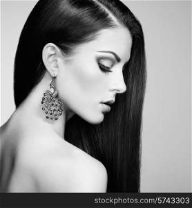 Portrait of beautiful brunette woman with earring. Perfect makeup. Fashion photo. Black and White
