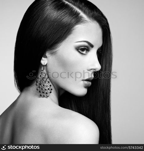 Portrait of beautiful brunette woman with earring. Perfect makeup. Fashion photo. Black and White