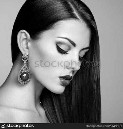 Portrait of beautiful brunette woman with earring. Perfect makeup. Fashion photo. Black and White