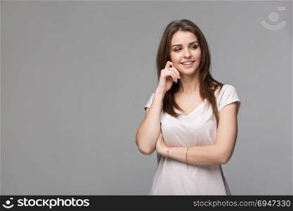 Portrait of beautiful brunette woman with natural make-up, on grey background. Portrait of beautiful brunette woman with natural make-up, on grey background.