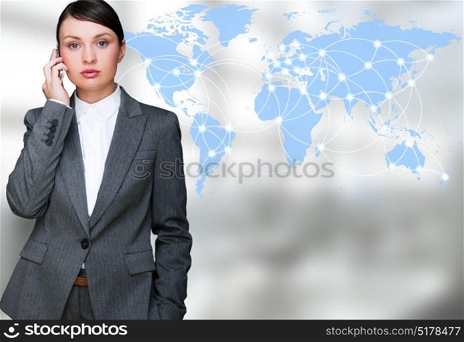 Portrait of beautiful business woman on the phone at her office near transparent virtual world map