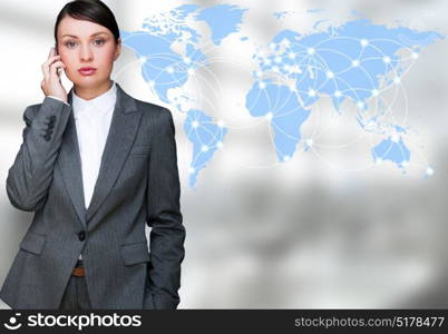 Portrait of beautiful business woman on the phone at her office near transparent virtual world map