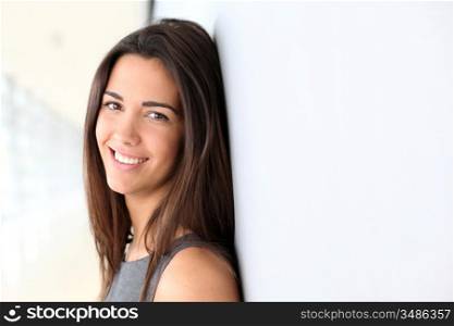 Portrait of beautiful businesswoman leaning against wall