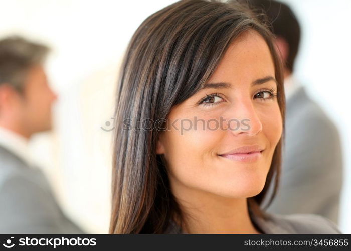 Portrait of beautiful businesswoman standing in front of group