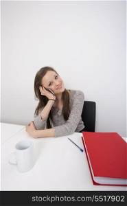 Portrait of beautiful businesswoman using cell phone at office desk