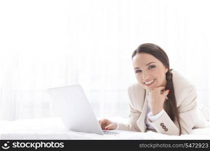 Portrait of beautiful businesswoman using laptop in hotel