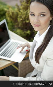 Portrait of beautiful businesswoman using laptop outdoors