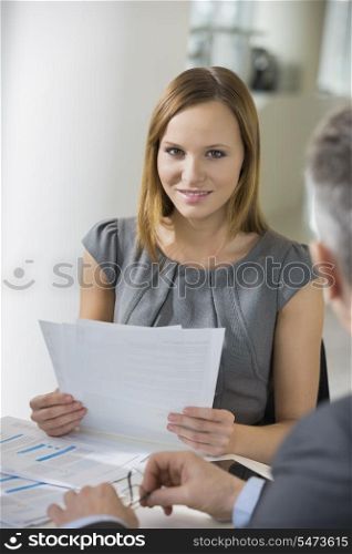 Portrait of beautiful businesswoman with documents in office cafeteria
