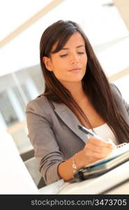 Portrait of beautiful businesswoman writing notes on agenda