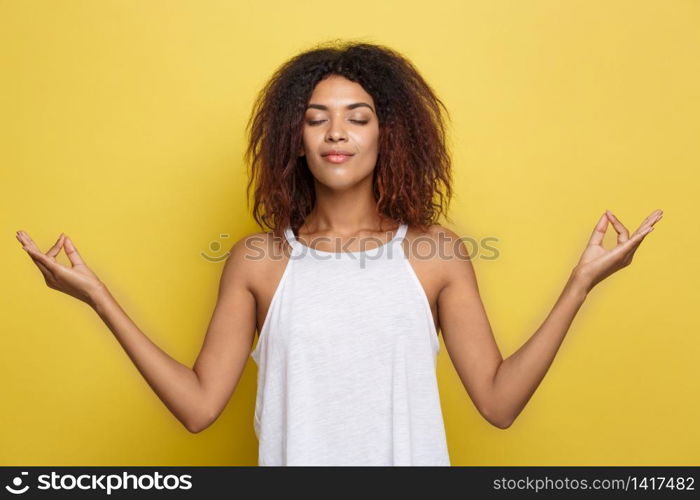 Portrait of beautiful calm young african american black female with Afro hairstyle practicing yoga indoors, meditating, holding hands in mudra gesture. Portrait of beautiful calm young african american black female with Afro hairstyle practicing yoga indoors, meditating, holding hands in mudra gesture.