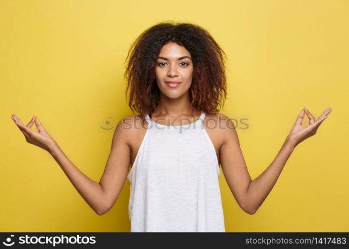Portrait of beautiful calm young african american black female with Afro hairstyle practicing yoga indoors, meditating, holding hands in mudra gesture. Portrait of beautiful calm young african american black female with Afro hairstyle practicing yoga indoors, meditating, holding hands in mudra gesture.