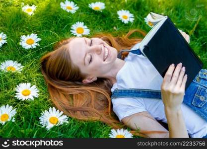 Portrait of beautiful caucasian smiling red-haired young woman, against∑mer green park.. Beautiful smiling red-haired young woman