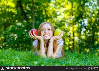 Portrait of beautiful caucasian smiling red-haired young woman, against summer green park.. Beautiful smiling red-haired young woman