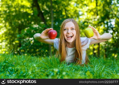 Portrait of beautiful caucasian smiling red-haired young woman, against summer green park.. Beautiful smiling red-haired young woman