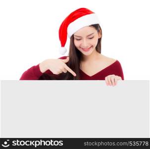 Portrait of beautiful christmas asian young woman in santa hat holding board with copyspace empty isolated on white background, xmas holiday concept.