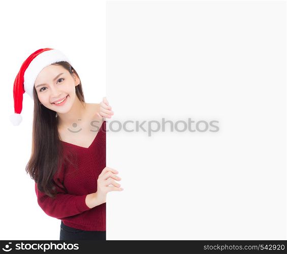 Portrait of beautiful christmas asian young woman in santa hat holding board with copyspace empty isolated on white background, xmas holiday concept.