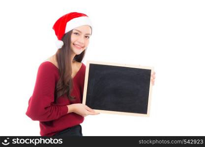 Portrait of beautiful christmas asian young woman in santa hat holding chalkboard with copyspace empty isolated on white background, xmas holiday concept.