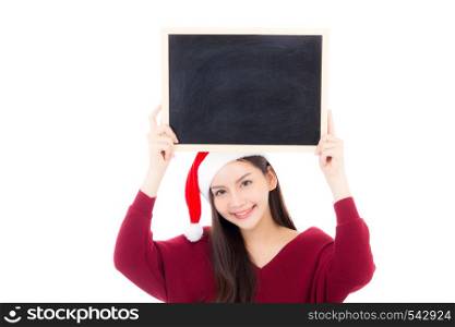 Portrait of beautiful christmas asian young woman in santa hat holding chalkboard with copyspace empty isolated on white background, xmas holiday concept.