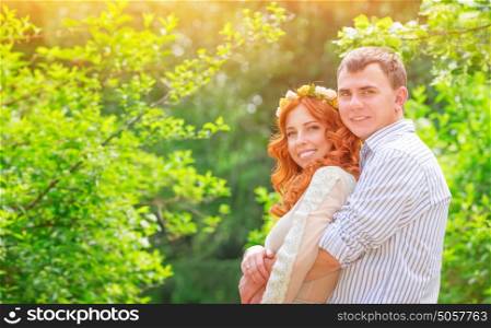 Portrait of beautiful couple in love hugging in sunny day in the park, happy wedding day, new family concept