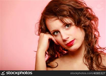 Portrait of beautiful curly young woman girl on pink background with blank copy space. Studio shot. Female beauty.