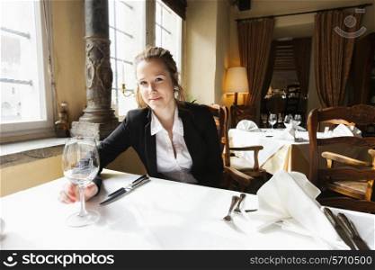 Portrait of beautiful customer with wine glass at restaurant table