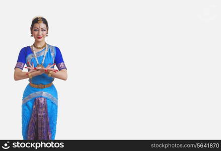 Portrait of beautiful dancer performing Bharatanatyam against white background