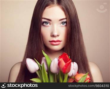 Portrait of beautiful dark-haired woman with flowers. Fashion photo