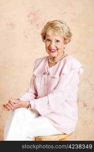 Portrait of beautiful, elegant senior woman sitting on a stool.